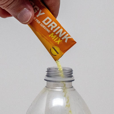 Lemonade Energy Drink Mix being poured into water bottle 